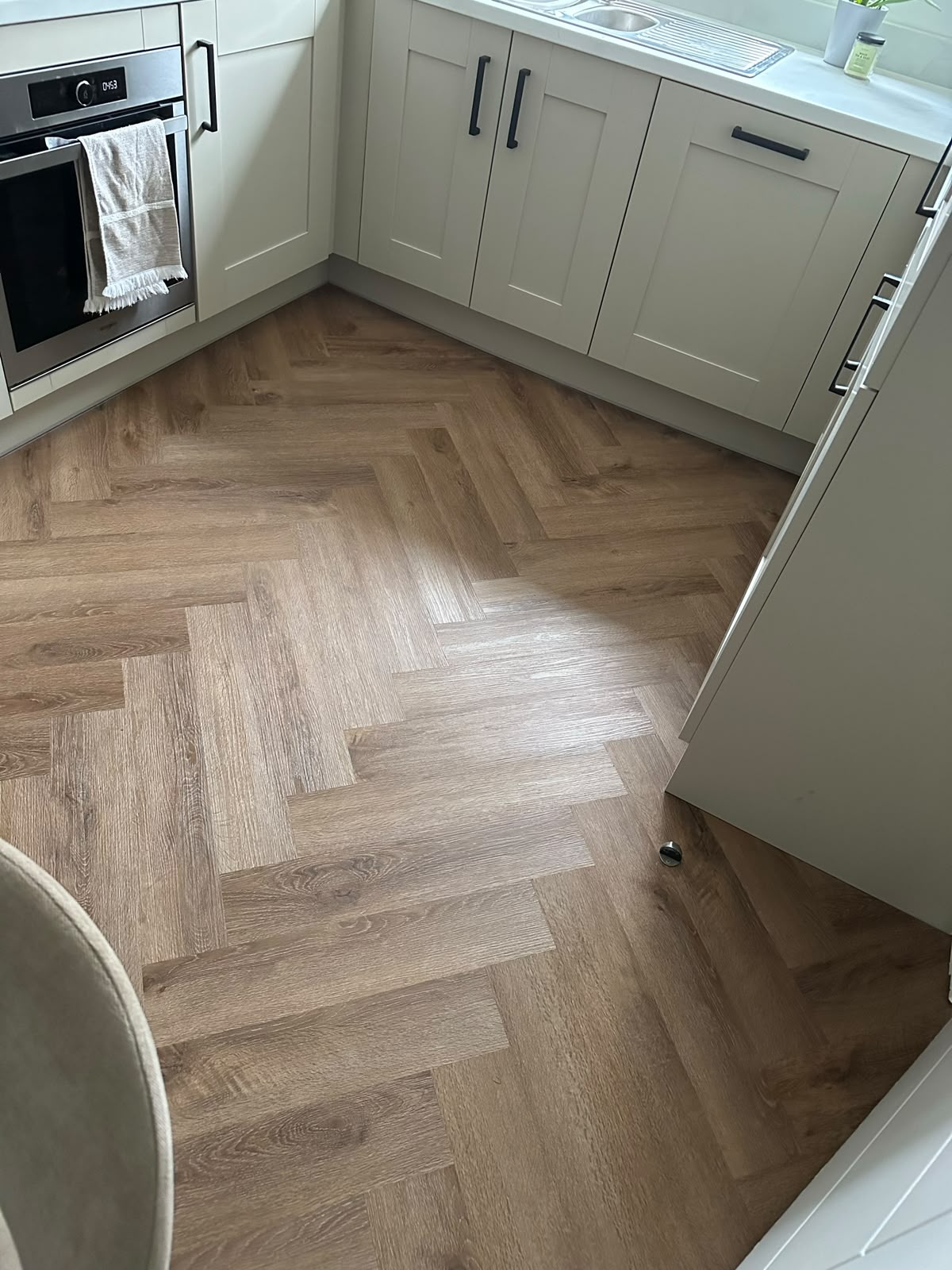 Light oak herringbone LVT fitted through a fitted kitchen