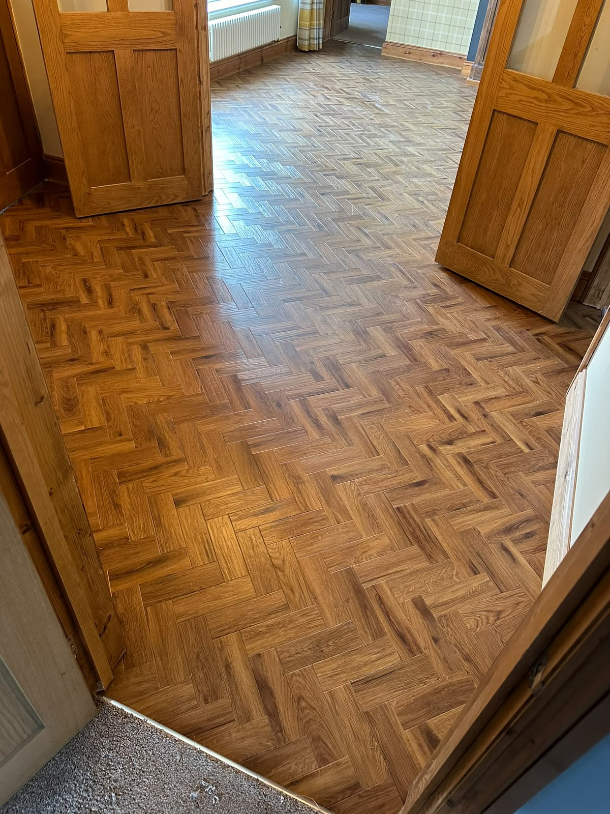 Dark parquet-effect flooring in a hallway