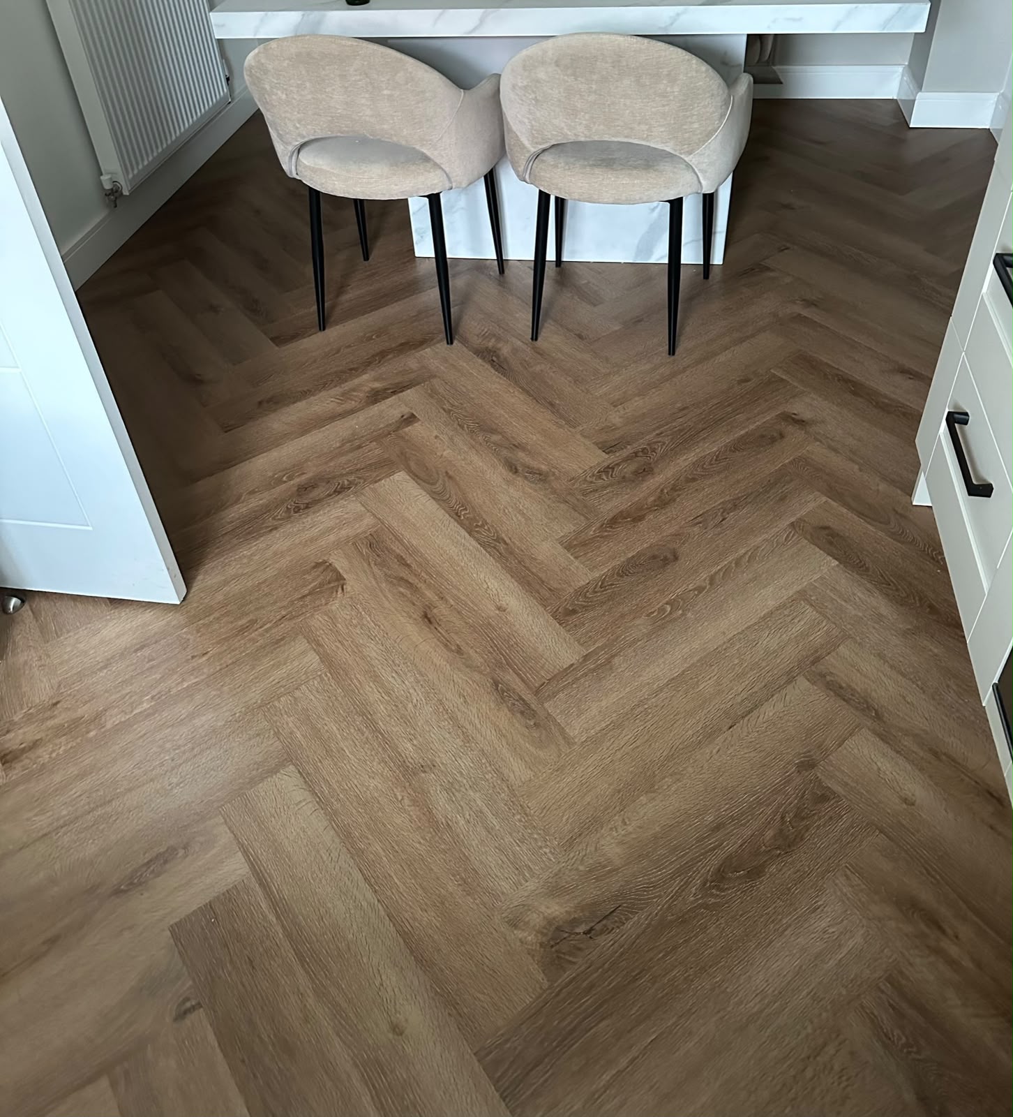Oak-effect herringbone LVT in a dining area