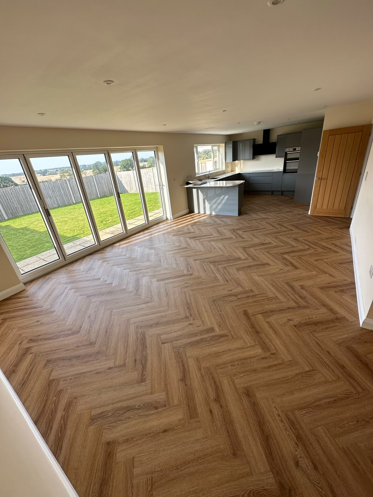 Herringbone LVT in an open-plan kitchen with bi-fold doors