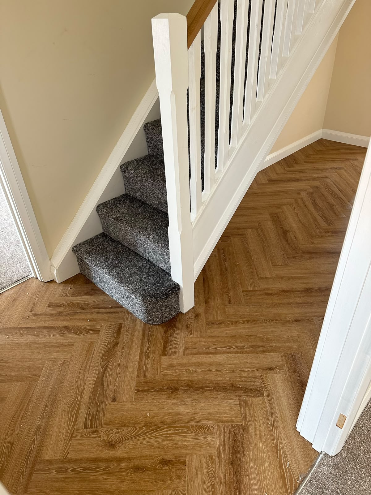 Herringbone LVT hallway with carpeted stairs
