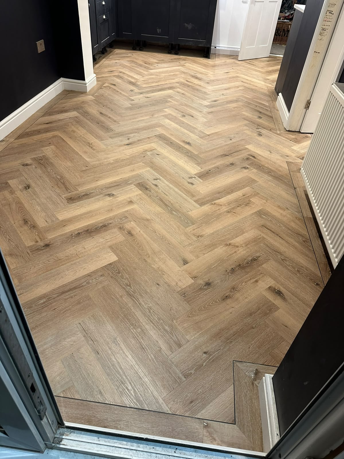 Light oak herringbone LVT in a modern kitchen