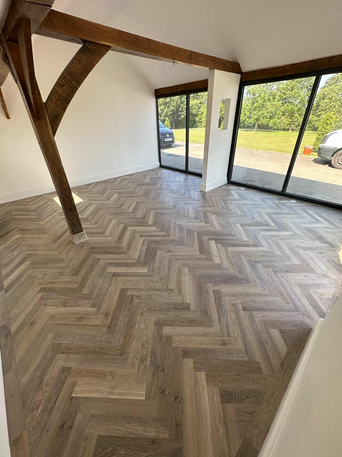 Grey herringbone LVT in a garden room with bi-fold doors